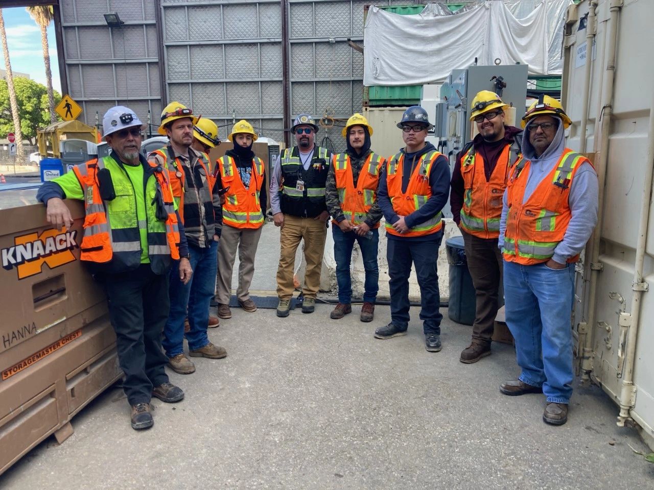 Nine G2.0 crew members standing together on a job site in hard hats and high visibility vests, several of them branded G2.0.