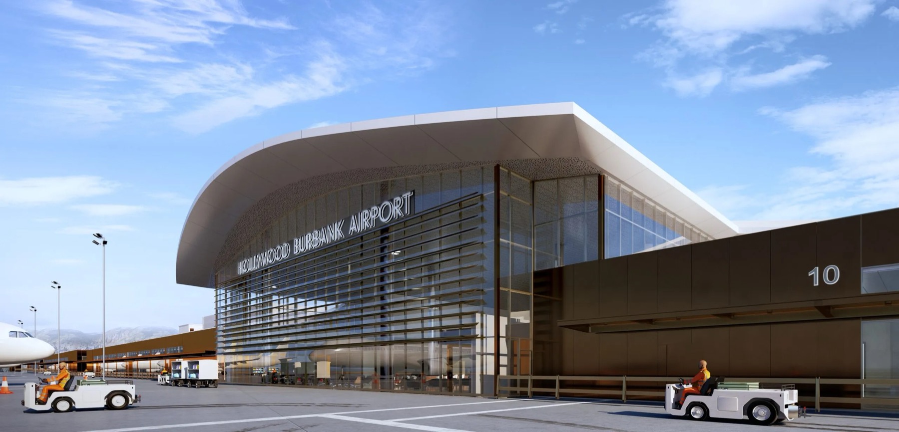 The replacement terminal at Hollywood Burbank Airport, a curved roof over a glazed and louvred facade, with ground crew and baggage tugs on the apron.