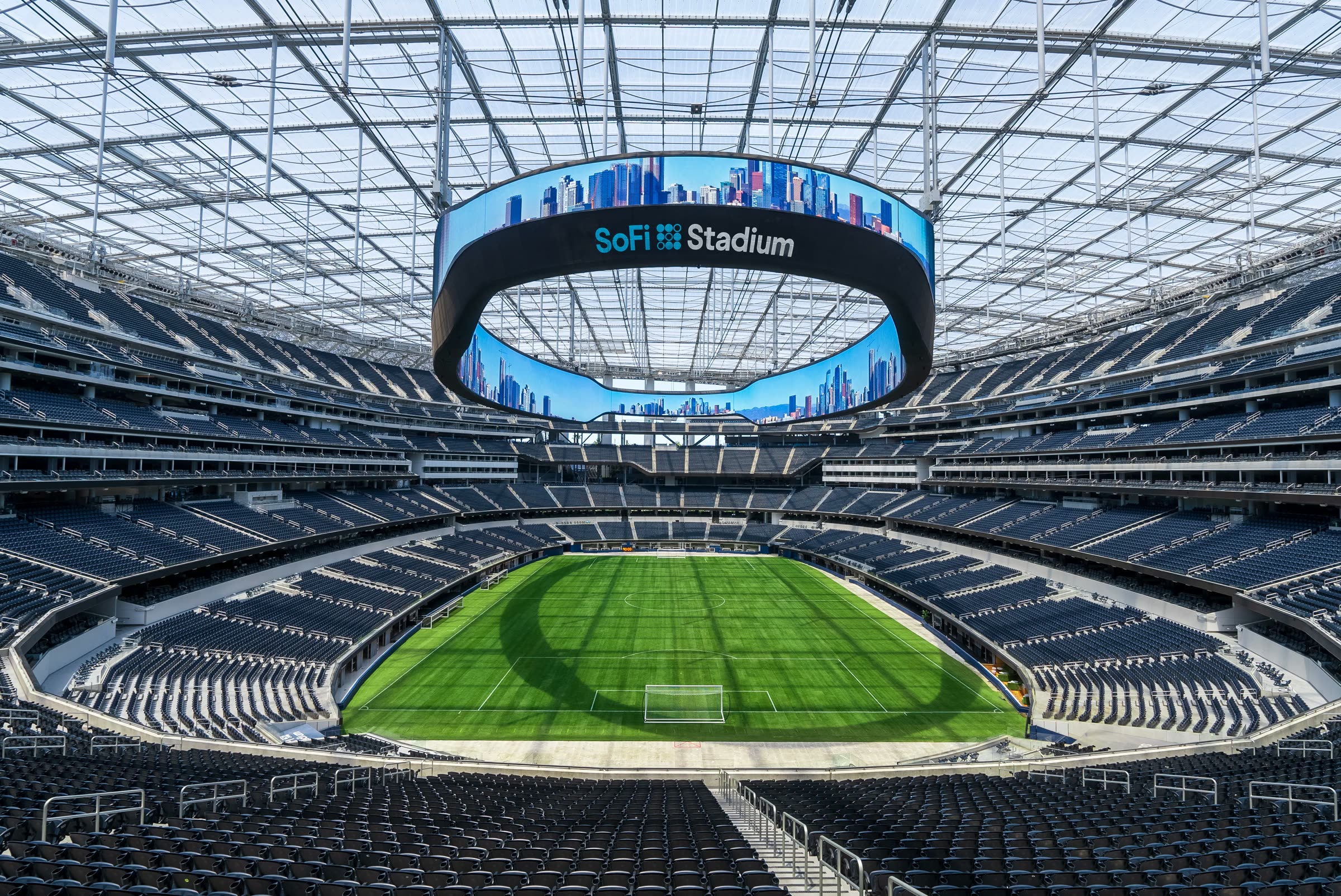 The interior bowl of SoFi Stadium, the Oculus video board suspended over the field under the translucent roof.
